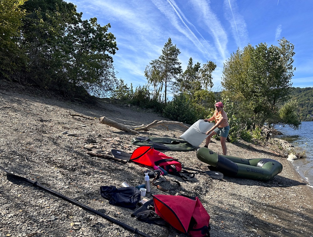 Puster en packraft op ved søbredden under et packrafting-eventyr i Eifel, Tyskland
